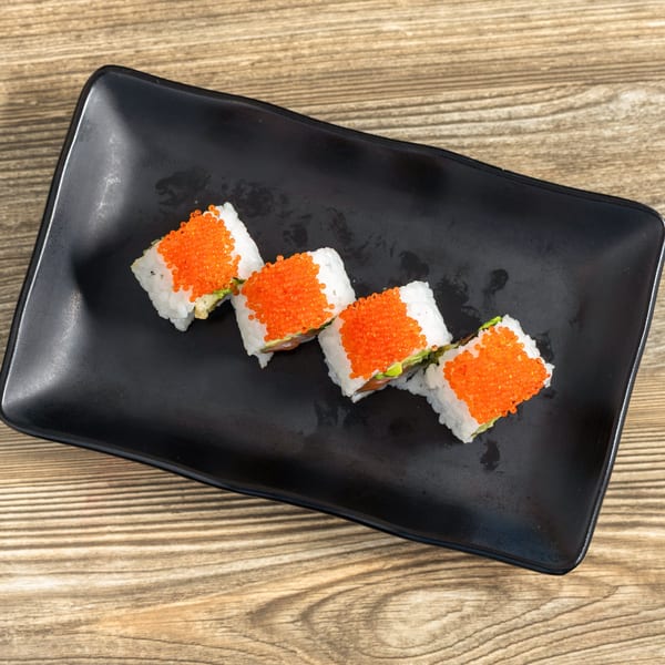Four pieces of Sushi Hana sushi with bright orange roe on a black rectangular plate.